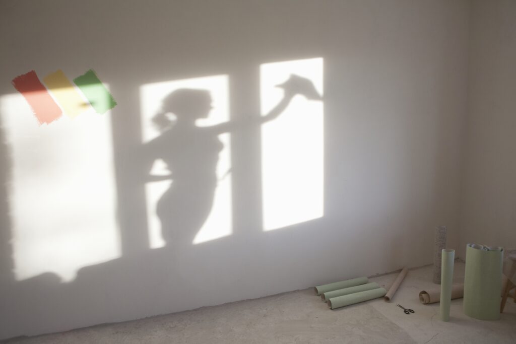 Shadow of woman painting the room